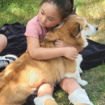 Norma being hugged by a young girl.