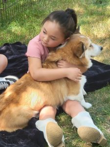 Norma being hugged by a young girl.